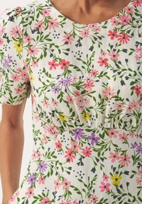 Robe fleurie avec un fond blanc orné de fleurs roses, violettes et jaunes, corsage froncée et manches courtes. Tissu léger au toucher doux.