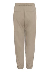 Pantalon beige à taille élastique avec poches passepoilées à l'arrière et poignets élastiqués aux chevilles, vu de dos.