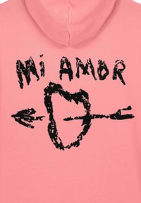 Hoodie rose avec un texte noir "Mi Amor" accompagné d'un motif en forme de cœur et d'une flèche. Texture de tissu lisse avec une coupe décontractée.