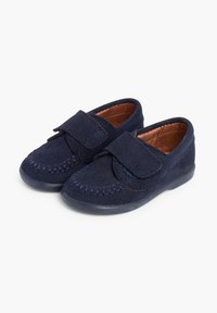 Souliers en daim bleu marine avec un bout arrondi, des détails cousus et une sangle en Velcro pour la fermeture. Semelle en caoutchouc pour une meilleure adhérence.