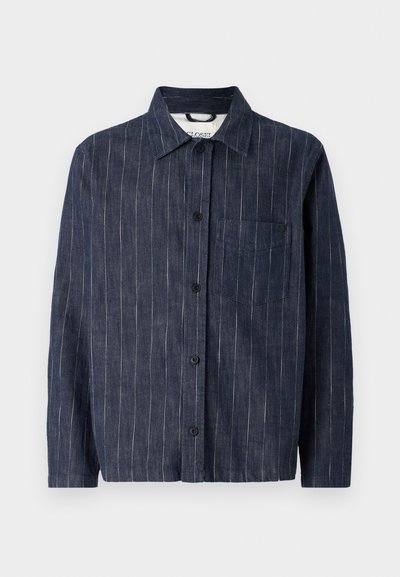 Tmavě modrá košile na knoflíky s vertikálními pruhy, límcem, kapsou na hrudi a dlouhými rukávy. Vyrobena z lehkého materiálu.