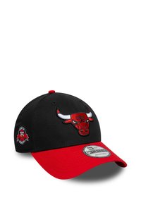 Gorra negra con visera roja, presenta un logo bordado de los Chicago Bulls en el frente y un logo circular en el costado. Diseño ajustable 9FORTY.