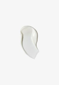 Smooth white cream smear with glossy texture on a plain light background, suggesting skincare or cosmetic product.