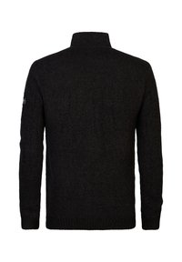 Svart stickad tröja med hög krage och ribbad textur. Har långa ärmar och en etikett på vänster axel. Baksidan visas.