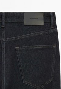 Donkerblauwe denim jeans van achteren, met één achterzak en een label met de merknaam "Massimo Dutti" erop gestikt.