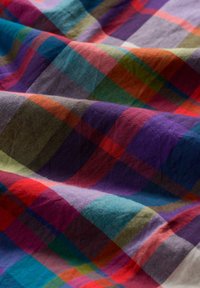 Menvrstvená bavlnená tkanina s kockovaným vzorom v červenej, purpurovej, zelenej a modrej farbe; mäkká textúra; voľne sa splýva.
