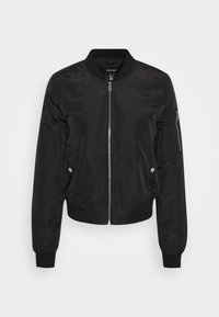 Veste bomber noire avec fermeture éclair sur le devant, poignets et col côtelés, poches latérales à pression et poche zippée sur la manche.