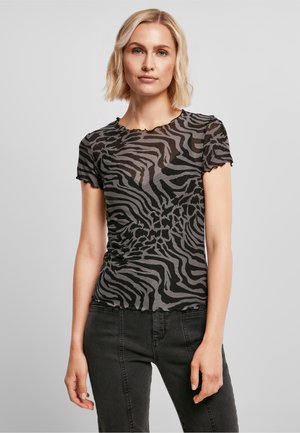Black and grey zebra-striped short-sleeve t-shirt with a round neckline and scalloped edges, paired with dark jeans.
