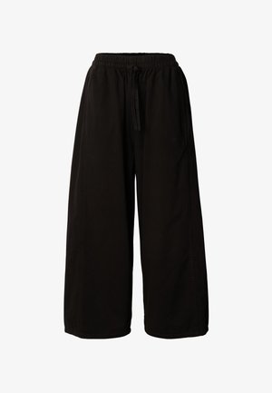 Juodos plačios kelnės su elastinga juosmens juosta ir raišteliu, su šoniniais kišenėmis, pateiktos prieš baltą foną.