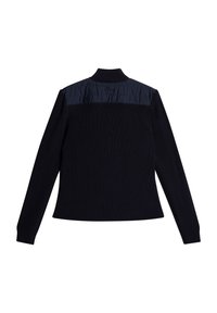 Svart långärmad stickad tröja med vadderad marinblå axelpanel och hög ribbad krage, sedd bakifrån mot vit bakgrund.