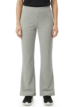 Modèle portant un pantalon gris à jambes larges et des baskets noires sur fond blanc.