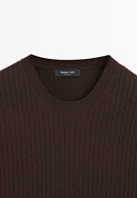 Hnědý žebrovaný pletený svetr s kulatým výstřihem, texturovaným kabelovým vzorem a etiketou s názvem značky Massimo Dutti.