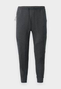 Tamsiai pilki Nike džinsai su raišteliu juosmenyje, užtrauktuku šonine kišenė, siaurėjančiomis kojomis ir raukiniais ant pūko, ant balto fono.