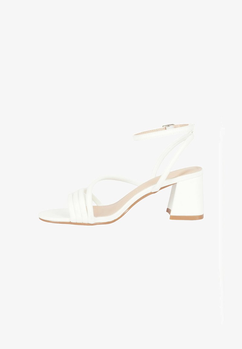 Sandal con tacco bianco e design con punta aperta, dotato di molteplici cinturini e tacco largo. Texture liscia e cinturino regolabile alla caviglia.
