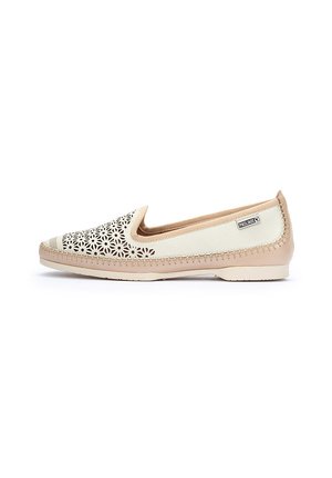 Zapato ligero tipo slip-on con una base de cuero beige y un intrincado patrón floral de cortes en la parte superior. Forro de tela suave y suela flexible.