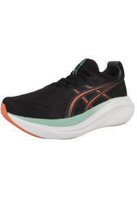 Botte de sport noire avec une tige texturée, accentuée par des détails orange et vert menthe, dotée d'une semelle blanche rembourrée et d'un système de laçage.