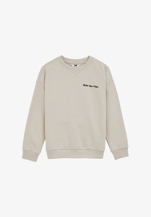 Bež pulover z okroglim izrezom, z rebrastimi manšetami in spodnjim robom, z črnim napisom "Ride the Vibe" na levi prsni strani.