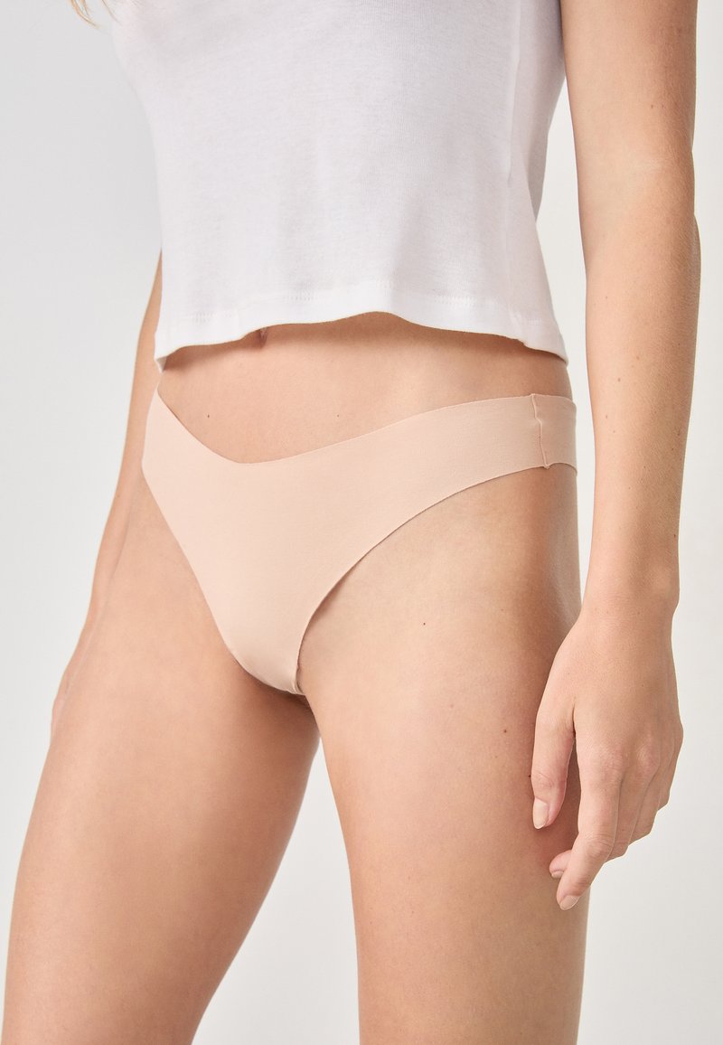 Bajo de bikini nude sin costuras con una textura suave y lisa y un diseño de cintura baja. Cuenta con una banda minimalista.