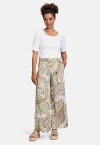 Volné, vzorované kalhoty s širokými nohavicemi v multikolorovaném paisley vzoru; spárovány s přiléhavým bílým topem s krátkým rukávem. Jemná textura, lehký materiál.