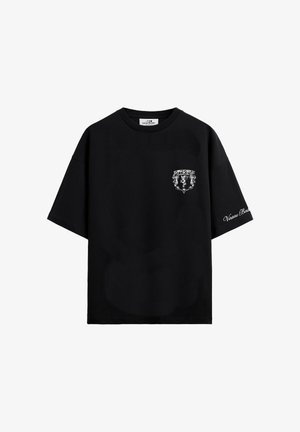 Musta lyhythihainen T-paita, jossa vasemmassa rinnassa pieni valkoinen grafiikka ja oikeassa hihassa valkoinen kaunokirjoitusfontilla oleva teksti.