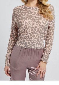 Jasnoróżowy i beżowy sweter w panterkę z okrągłym dekoltem i długimi rękawami, zestawiony z błyszczącymi, jasnofioletowymi spodniami z elastyczną talią.