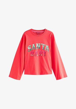 Koraļkrāsas garām piedurknēm T-krekls, izgatavots no kokvilnas. Priekšpusē ir uzraksts "SANTA BABY" daudzkrāsainās, rakstainās burtiem. Apaļš dekoltē.