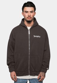 Dark gray zip-up hoodie with large front pockets, ribbed cuffs, and embroidered white logo on the left chest. Soft fabric, relaxed fit.