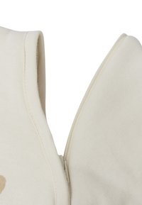 Cotton top in off-white with a zip closure. Features a soft texture, smooth seam detailing, and minimalistic design.