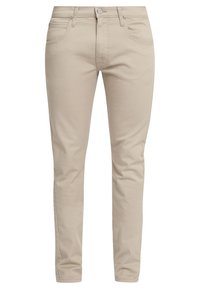 Släta beige byxor med framfickor, bälteslingor, dragkedja och knappstängning, visade mot en vit bakgrund.