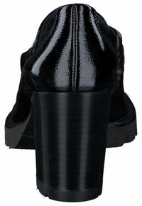 Scarpe con tacco alto in vernice nera, dotate di un tacco chunky, caratterizzate da una superficie liscia e cuciture distintive sul retro.
