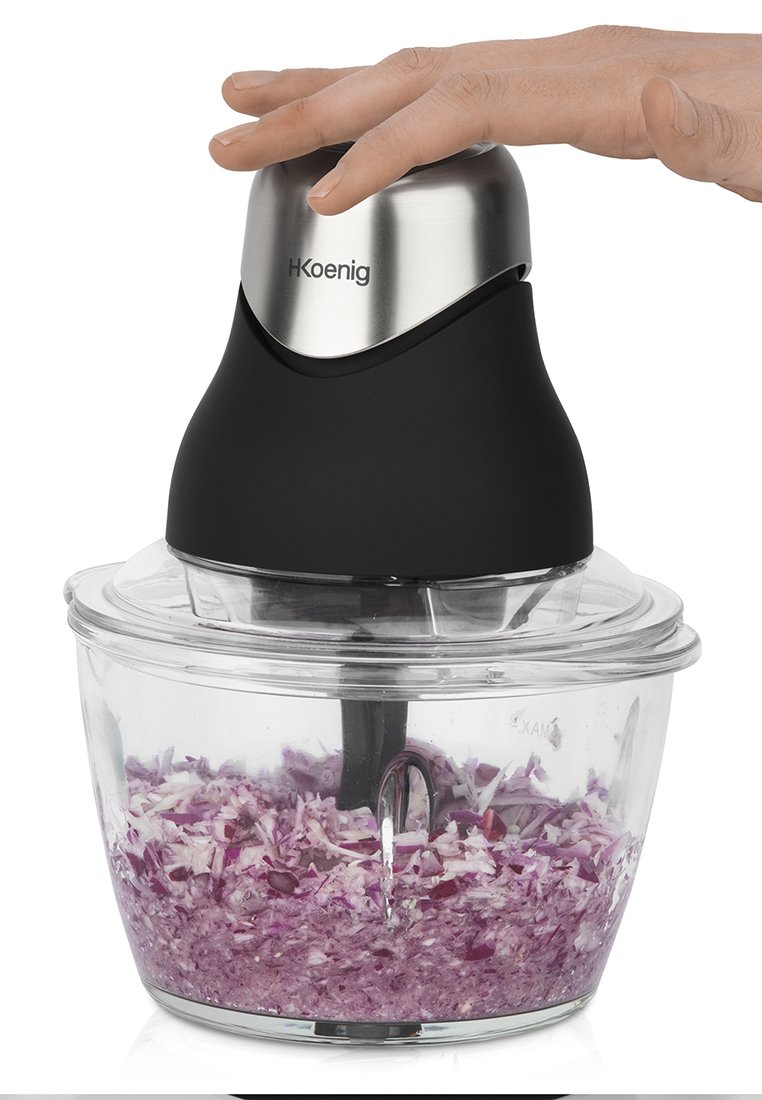 Hachoir électrique avec un dessus en acier inoxydable et en plastique noir. Un bol en verre transparent contient des oignons violets finement hachés.