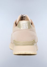 Beżowo-złoty but sportowy widziany od tyłu, z logo na pięcie i oznaczoną pętelką do ściągania, na jasnoszarym tle.