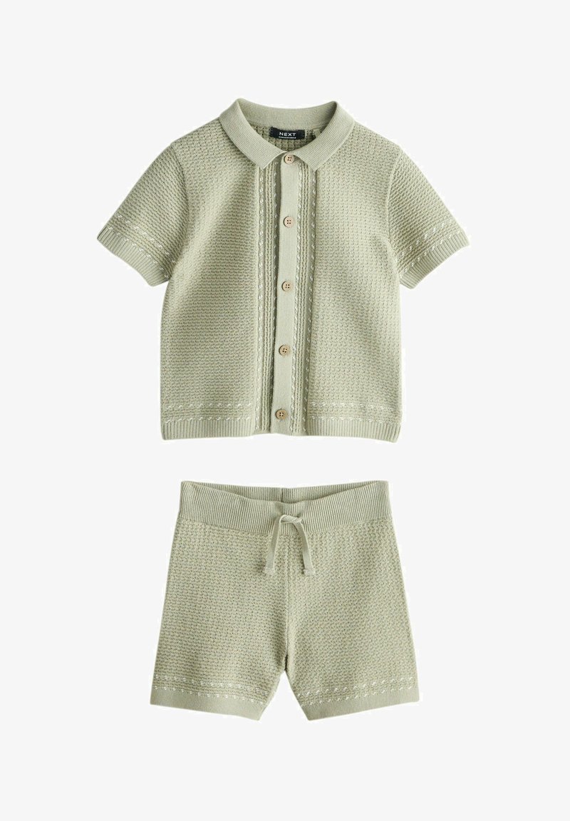 Világoszöld kötött rövid ujjú galléros felső, gombos, hozzáillő rövidnadrággal, amit húzózsinór díszít a deréknál és mintás textúrával.