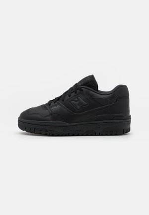 Baskets noires New Balance 550 avec tige en cuir et mesh, design lacé et semelle en caoutchouc robuste vues de côté.