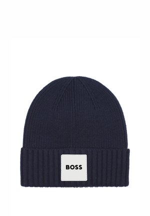 Bonnet en maille côtelée bleu marine avec revers, orné d'un patch carré blanc portant la mention BOSS en lettres noires.