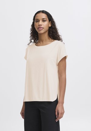 T-shirt beige chiaro con scollatura rotonda, maniche corte arrotolate e vestibilità rilassata. Fessure laterali all'orlo per un tocco decorativo. Design minimalista.
