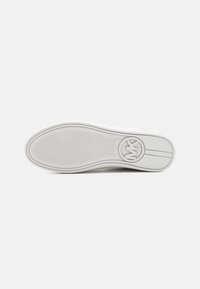 Semelle de sneakers blanche en caoutchouc texturé pour une meilleure adhérence, présentant un logo circulaire et des accents linéaires subtils le long du bord.