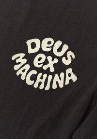 Black t-shirt featuring a circular white graphic with the text "DEUS ex MACHINA" in a playful, rounded font in the center.