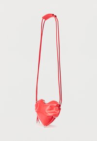 Κόκκινη τσάντα χιαστί σε σχήμα καρδιάς από λείο δέρμα, με κλείσιμο με φερμουάρ και ρυθμιζόμενους κόκκινους ιμάντες με ασημένιες μεταλλικές λεπτομέρειες.