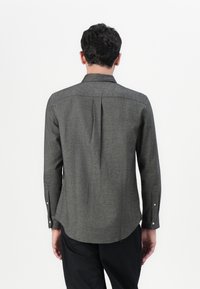 Grå mønstrete skjorte med lange ermer, bakfold, krage og knappede mansjetter. Stoffet har en teksturert overflate og en buet kant.
