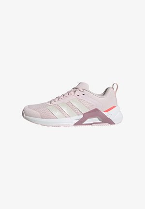 Jasnoróżowy sportowy sneaker z białą podeszwą, trzema białymi bocznymi paskami i liliowym elementem wsparcia przy pięcie na białym tle.