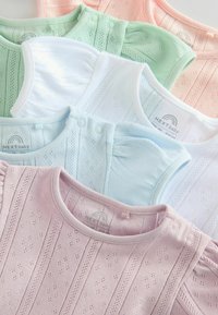 Set med babytoppar i pastellfärger: rosa, blå, grön, vit och persika. Tillverkade av bomull, med textur av små mönster och tryckknappar vid axlarna.