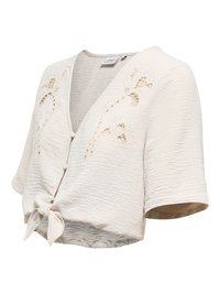 Blouse courte crème à manches mi-longues, lien à l'avant, boutons et broderie florale ajourée de chaque côté de l'encolure.