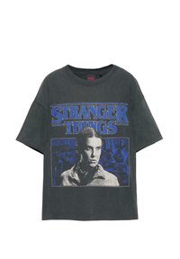Tricou din bumbac gri, cu imprimeu grafic albastru având textul "Stranger Things" și portretul unui personaj. Croială lejeră cu mâneci scurte.