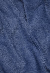 Soft, textured fabric in deep blue, featuring a fuzzy surface with varying pile height and subtle sheen, ideal for cozy applications.