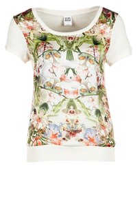 T-shirt med blomsterprint og korte ærmer, med en hvid krop og et livligt, symmetrisk blomsterdesign i pink, grønne og blå nuancer.