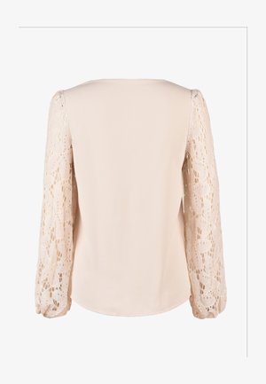 Blusa con cuerpo de tela lisa de color rosa pálido y mangas largas de encaje transparente con patrones florales y detalle fruncido en el puño.