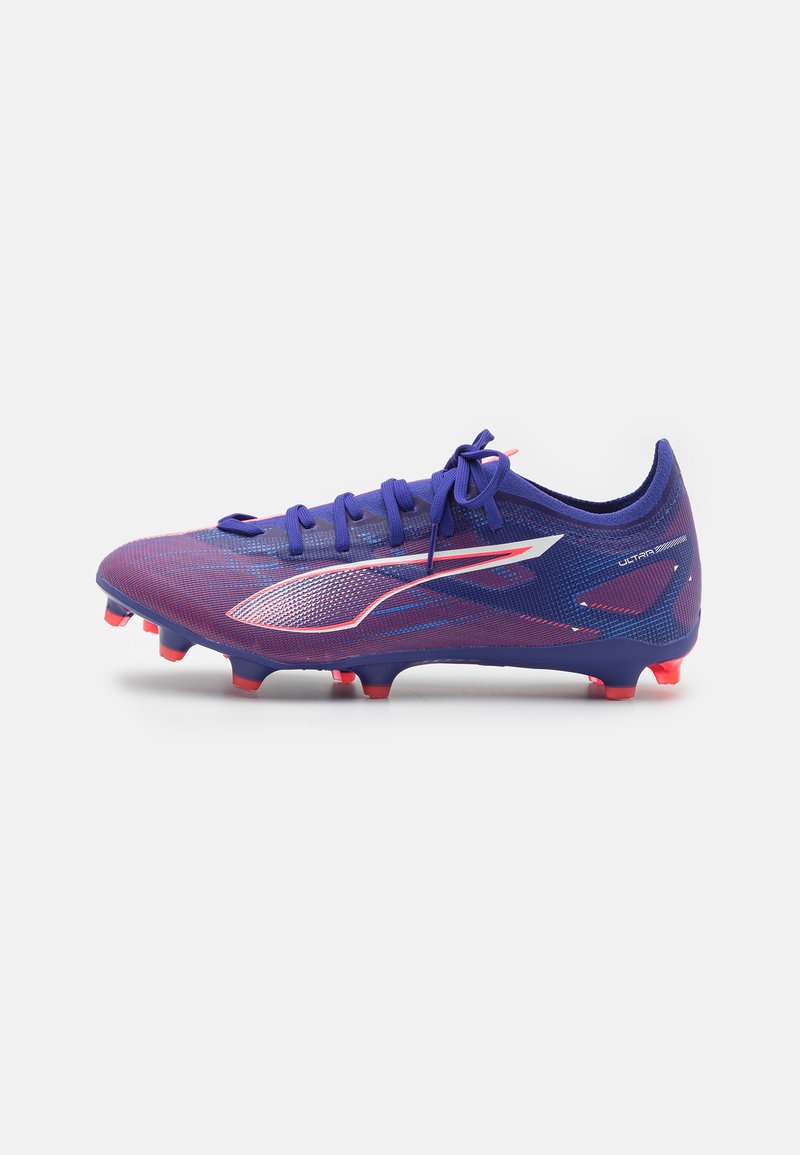 Botín de fútbol púrpura con acabado texturizado, con acentos rosas, seis tacos angulares y un diseño aerodinámico. Los cordones están atados en la parte delantera.