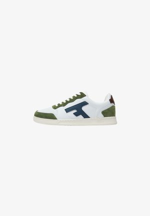 Witte sneaker met groene suède accenten, marineblauwe logo aan de zijkant, bruine hieltab en witte zool.