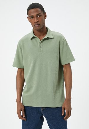 Poloshirt met korte mouwen in een zachte, gestructureerde lichtgroene stof, met een kraag, drie-knopenlijst en een relaxed fit. Casual ontwerp en styling.
